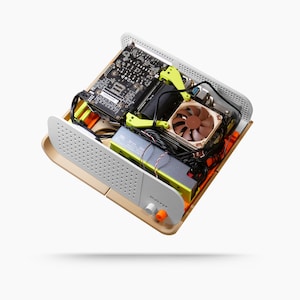 May include: A computer case with internal components visible. The case is beige and white with a perforated front panel. Inside are a motherboard, fan, and other hardware, with yellow and orange accents. The text "Makey" is visible on the front.
