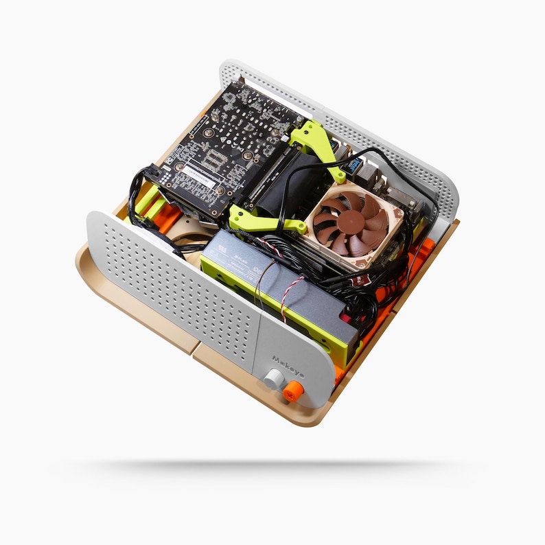 May include: A computer case with internal components visible. The case is beige and white with a perforated front panel. Inside are a motherboard, fan, and other hardware, with yellow and orange accents. The text "Makey" is visible on the front.