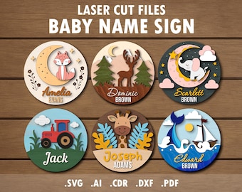 May include: Wooden baby name signs with laser-cut designs. Each sign features a different theme: a fox on a moon, a deer in a forest, an elephant on a crescent moon, a tractor, a giraffe, and a sailboat. The signs include names and the text "BABY NAME SIGN".