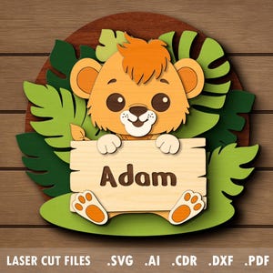 Può includere: Decorazione da parete in legno con un cucciolo di leone e il nome "Adam" su un cartello. Il leone è arancione e marrone chiaro, circondato da foglie verdi e uno sfondo in legno marrone. Il design è tagliato al laser.