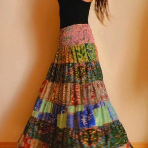 Pu&ograve; includere: Lunga gonna patchwork con un vivace mix di colori e motivi. La gonna presenta un'ampia fascia elastica in vita e un design a balze. Il tessuto della gonna &egrave; un mix di stampe floreali, paisley e geometriche nelle tonalit&agrave; del rosso, blu, verde e oro.