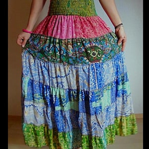 Pu&ograve; includere: Una gonna lunga a pi&ugrave; strati con un design patchwork. La gonna presenta una fascia elastica verde, una sezione rosa fantasia, una sezione fantasia verde acqua e verde, e strati fantasia blu e verdi. La gonna &egrave; realizzata in tessuto leggero.