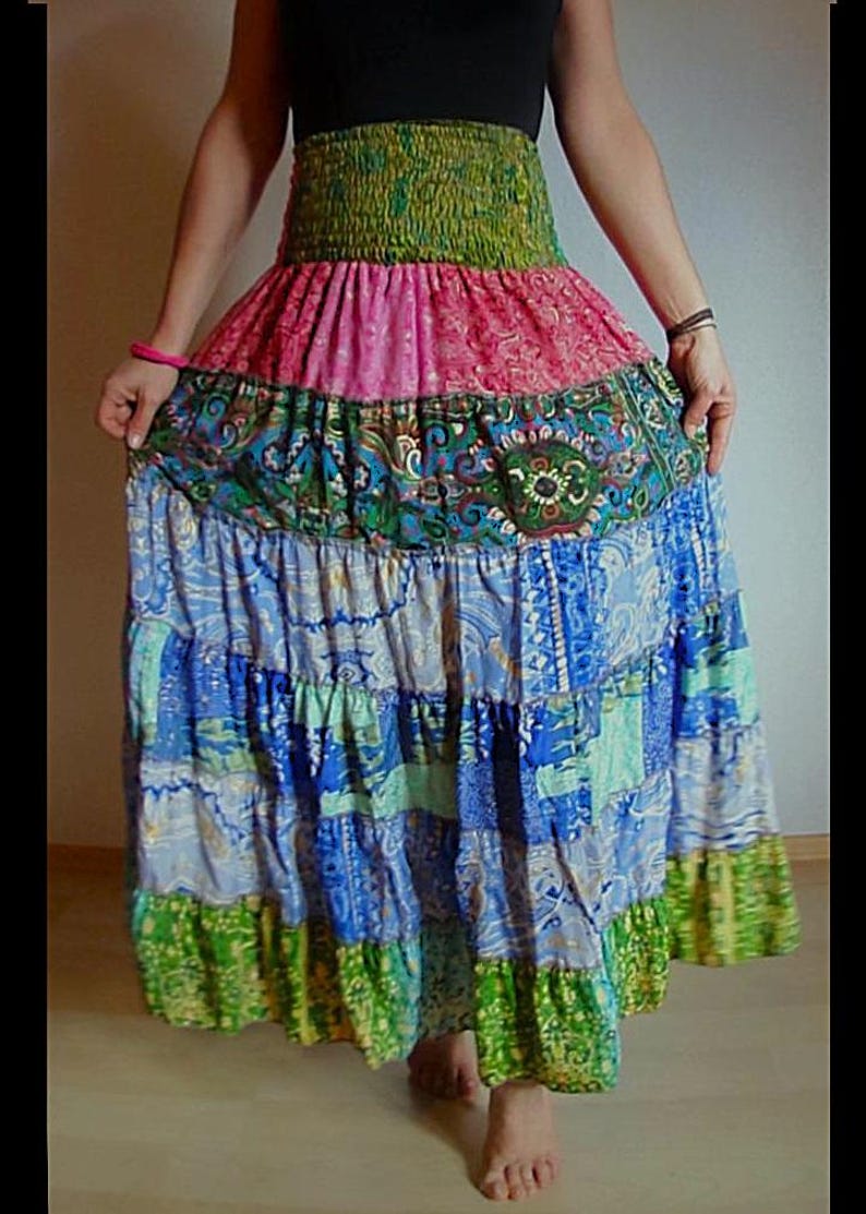 Pu&ograve; includere: Una gonna lunga a pi&ugrave; strati con un design patchwork. La gonna presenta una fascia elastica verde, una sezione rosa fantasia, una sezione fantasia verde acqua e verde, e strati fantasia blu e verdi. La gonna &egrave; realizzata in tessuto leggero.