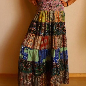 Pu&ograve; includere: Una lunga gonna patchwork con un vivace mix di colori e motivi. La gonna presenta un'ampia fascia elastica in vita e un design a pi&ugrave; livelli, con vari quadrati di tessuto nelle tonalit&agrave; di blu, verde, rosso e oro. La gonna &egrave; lunga fino alla caviglia.