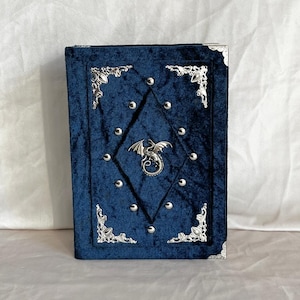 Könnte beinhalten: Ein Set aus drei Keramikbechern mit gesprenkelter, matter Oberfläche. Jeder Becher hat eine andere Farbe: hellblau, cremefarben und grau. Die Becher haben ein schlichtes, modernes Design mit runder Form und Henkel.