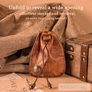 Puede incluir: Una bolsa de cuero marrón con cierre de cordón y cierre metálico. La bolsa tiene un pequeño emblema metálico y el texto "Unfold to reveal a wide opening". El peso es de 80g.