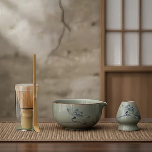 Może przedstawiać: Zestaw do herbaty matcha z przezroczystym szklanym naczyniem z bambusową trzepaczką i łyżką, jasnoniebieską ceramiczną miską z dzióbkiem i małym ceramicznym uchwytem. Każdy ceramiczny element ma niebieski kwiatowy wzór.