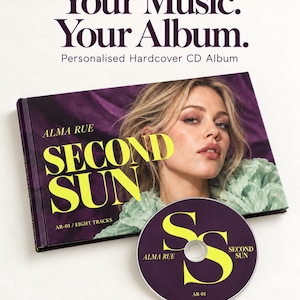 May include: A personalized hardcover CD album titled Second Sun by Alma Rue, featuring a purple cover with a portrait of a person and bright yellow text. The set includes a matching purple CD with yellow SS branding and the text Alma Rue Second Sun AR-01.