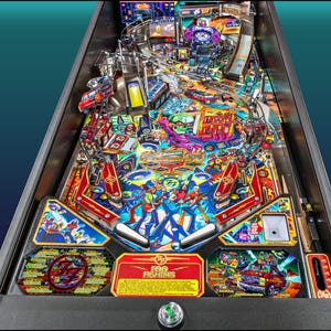 Puede incluir: Una colorida máquina de pinball con temática de Foo Fighters. El campo de juego presenta ilustraciones vibrantes, incluyendo miembros de la banda, un coche rojo y el logotipo de la banda. La máquina tiene varias rampas, parachoques y objetivos.