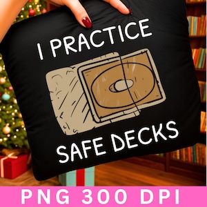 May include: Black pillow with the text "I PRACTICE SAFE DECKS" in white. The pillow features a brown and beige graphic of a CD case. The bottom of the pillow has the text "PNG 300 DPI".