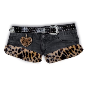 Op de afbeelding: Donkergrijze denim shorts met luipaardprint en een zwarte, met studs bezette riem met een zilveren gesp. Een kleine, hartvormige bedel met een luipaardprint hangt aan de shorts.