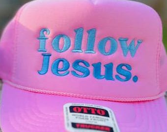 May include: Two trucker hats with the phrase "follow jesus." embroidered on the front. One hat is blue and the other is pink.