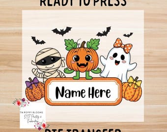May include: A DTF transfer featuring a Halloween design with a mummy, pumpkin, and ghost. The design includes the text "Ready to Press", "Name Here", and "DTF Transfer". The image has a light wood grain background.