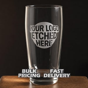 May include: A clear pint glass with the text "YOUR LOGO ETCHED HERE" in a white, circular design. Below the glass, the words "BULK PRICING DELIVERY" are displayed on a black background. The glass sits on a wooden surface.