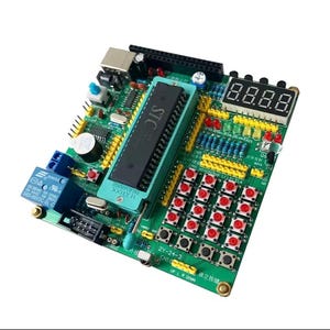 Puede incluir: Un kit de desarrollo de placa de circuito impreso verde que presenta un microcontrolador STC central grande en un zócalo Textool, una pantalla LED de siete segmentos de cuatro dígitos, un relé azul, varios botones rojos, cabezales amarillos y componentes.