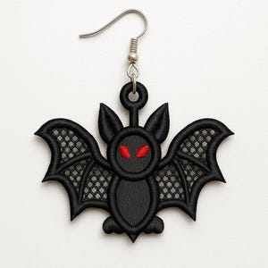 May include: Black embroidered bat earring with red eyes and a silver-colored hook. The bat has detailed wings with a mesh design. This gothic-themed jewelry is perfect for Halloween or everyday wear.