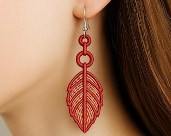 Könnte beinhalten: Rote und goldfarbene, bestickte Federohrringe. Die Ohrringe haben ein Blattdesign mit aufwendigen Stichen und einer hängenden Kette. Sie sind an einem silbernen Haken befestigt. Ein einzigartiges Accessoire.