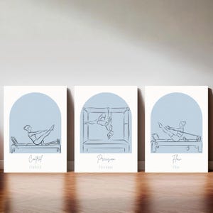 Puede incluir: Un conjunto de tres l&aacute;minas rectangulares blancas para pared con arcos azul claro. Cada l&aacute;mina muestra un dibujo lineal gris oscuro de una persona haciendo ejercicio en una m&aacute;quina de Pilates, con las palabras Control, Precision y Flow.