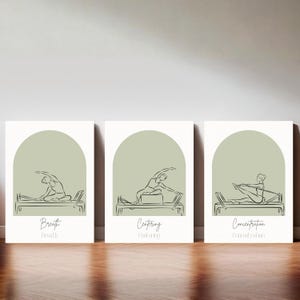 Puede incluir: Un conjunto de tres l&aacute;minas rectangulares para pared con arcos de color verde salvia y dibujos de l&iacute;neas negras de personas en reformadores de Pilates. Las l&aacute;minas incluyen el texto Breath, Centering y Concentration en letra cursiva.