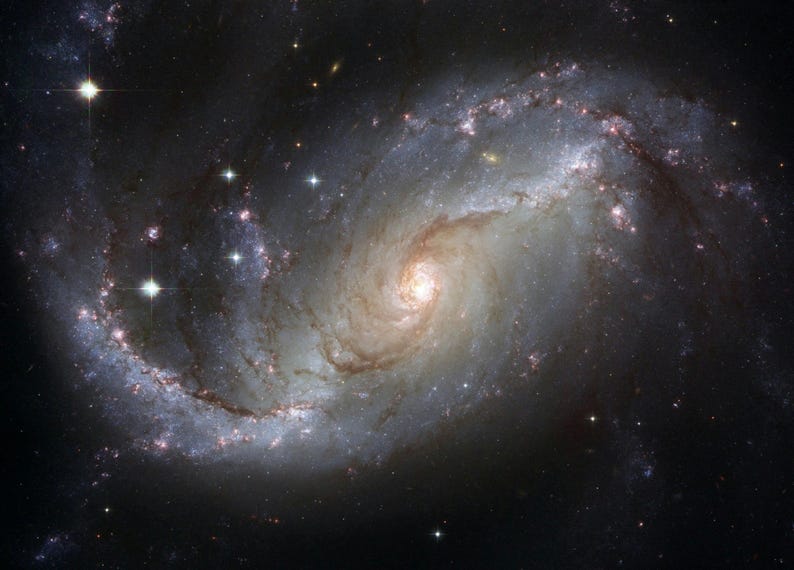 May include: A spiral galaxy with a bright, glowing center and swirling arms filled with stars and dust. The image showcases a cosmic structure with a mix of light and dark areas, and bright, distant stars.