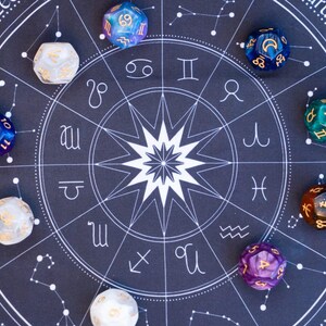 Peut inclure: Un tapis bleu fonc&eacute; avec un motif de carte astrologique blanche, repr&eacute;sentant des symboles du zodiaque et des constellations. Douze d&eacute;s multicolores &agrave; douze faces sont dispos&eacute;s autour du graphique. Les d&eacute;s sont de diff&eacute;rentes couleurs, dont le bleu, le vert, le violet et l'or.