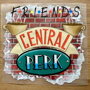 May include: A decorative image featuring the "Friends" logo with the words "FRIENDS" and "CENTRAL PERK". The design includes two coffee cups with steam, set against a brick wall background. The "PERK" is in a green oval.