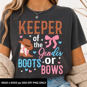 May include: Dark gray t-shirt with the text "KEEPER of the Gender BOOTS or BOWS" in brown, pink, and blue. The design includes a cowboy hat, boots, and a pink bow, with hearts and stars.