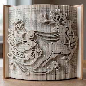 May include: A book art sculpture featuring folded pages that form the silhouette of Santa Claus in a sleigh being pulled by a reindeer with large antlers. The sculpture is created from the pages of a printed book with visible text throughout.