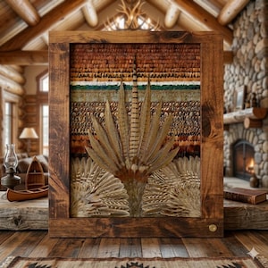 May include: A framed artwork featuring a detailed arrangement of feathers in shades of brown, tan, and cream. The feathers are arranged in a layered pattern, creating a textured and natural aesthetic. The artwork is encased in a rustic, dark wood frame, adding to its earthy appeal.