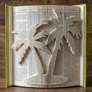 May include: A book with folded pages forming the shape of a palm tree. The book has a bright green spine and cover edges. The pages are filled with black printed text, and the intricate folding technique creates a three-dimensional palm tree silhouette.