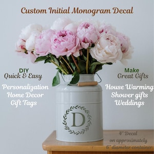 Puede incluir: Un recipiente de metal blanco con un asa de madera, que contiene un ramo de peonías rosas y blancas. El recipiente presenta una calcomanía con monograma con la letra "D" dentro de una corona. El texto incluye "Custom Initial Monogram Decal".