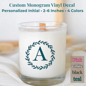 May include: A white candle in a clear glass with a teal monogram initial "A" inside a wreath. The text reads "Custom Monogram Vinyl Decal, Personalized Initial 2-6 Inches, 4 Colors". Available in pink, white, black, and teal.