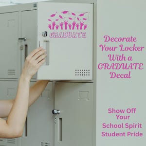 May include: A light grey locker with a pink "GRADUATE" decal. The decal features graduation caps and hands. The locker door is open, revealing the interior. Text on the right side reads "Decorate Your Locker With a GRADUATE Decal".