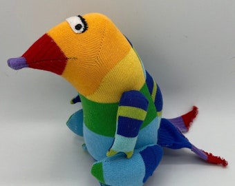 PICCOLO a silly bird like creature who was born on the Fourth of July. This sock toy has a striped coat in all the colors of the Rainbow.