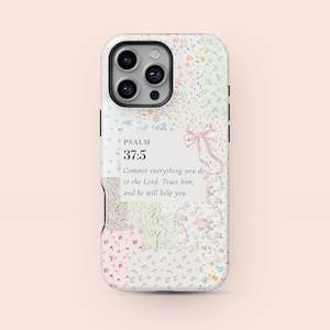 Puede incluir: Una funda para teléfono con estampado floral con fondo blanco y lazo rosa. La funda presenta el texto "PSALM 37:5" y una cita. La funda tiene una lente multicámara.