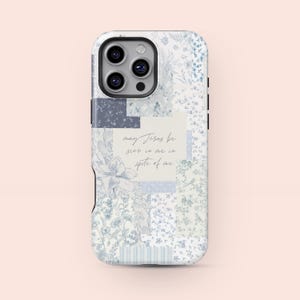 Puede incluir: Funda de teléfono con un diseño de patchwork floral en tonos azules y blancos. La funda presenta un recorte para la cámara y el texto "may Jesus be seen in me in spite of me" en escritura manuscrita.