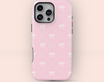 May include: Pink phone case with a repeating pattern of white bows and scalloped squares. The case has a camera cutout and black side buttons. The overall design is feminine and delicate.