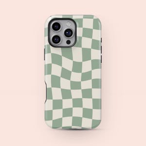 May include: A smartphone case featuring a wavy checkerboard design in sage green and cream. The case has a camera aperture and black side buttons. The phone case is designed to fit a smartphone.