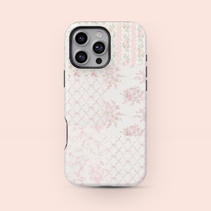 May include: A white phone case with a floral design. The case features a mix of patterns, including a trellis, vertical stripes, and floral bouquets, all in shades of pink and white. The case has a black camera module.