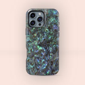 May include: A smartphone case with an iridescent, pearlescent finish. The case displays a swirling pattern of greens, blues, and browns, giving it a natural, organic appearance. The case has a camera module with three lenses.