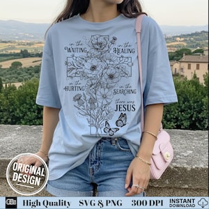 Woman in a light blue t-shirt modeling a black outline floral cross Jesus graphic design.