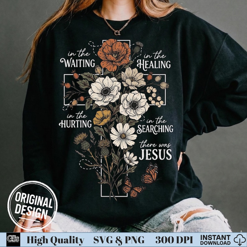 May include: Black sweatshirt featuring a floral cross design with the words "in the WAITING, in the HEALING, in the HURTING, in the SEARCHING, there was JESUS." The design includes flowers and butterflies. "ORIGINAL DESIGN" is also printed on the sweatshirt.