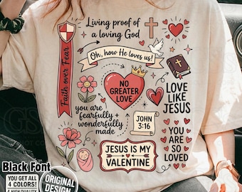 May include: Beige t-shirt with a graphic design featuring religious symbols and text. The design includes a cross, hearts, flowers, and the phrases "Living proof of a loving God" and "Jesus is my Valentine."