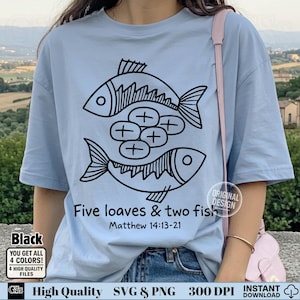 Könnte beinhalten: Hellblaues T-Shirt mit einer schwarzen Grafik von zwei Fischen und fünf Broten. Der Text "Five loaves & two fish" und "Matthew 14:13-21" sind darunter gedruckt. Das Shirt hat auch ein kleines "Original Design" Logo.