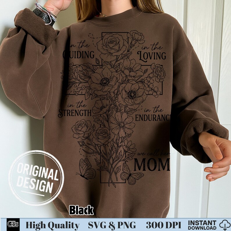 Woman wearing a brown sweatshirt featuring a black outline floral cross doodle and mom quote.