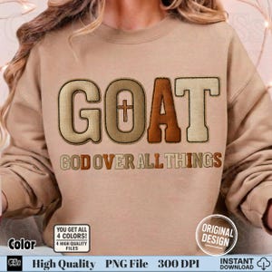 May include: A tan sweatshirt with the word "GOAT" in large, textured letters, with a cross in the "O". Below, the phrase "GOD OVER ALL THINGS" is printed. The design includes a small square with text that says "YOU GET ALL 4 COLORS! 4 HIGH QUALITY FILES".