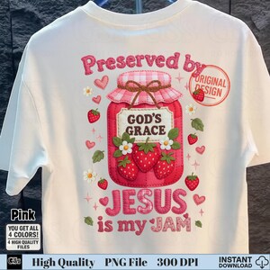 May include: White t-shirt featuring a pink graphic of a strawberry jam jar with the text "Preserved by God's Grace Jesus is my Jam". The design includes strawberries, hearts, and flowers. The shirt also has the text "Pink" and "Original Design".