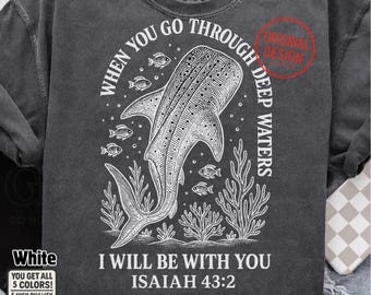 May include: Dark gray t-shirt featuring a white illustration of a whale shark, fish, and aquatic plants. Text reads "WHEN YOU GO THROUGH DEEP WATERS, I WILL BE WITH YOU ISAIAH 43:2". The shirt has a vintage, washed look.