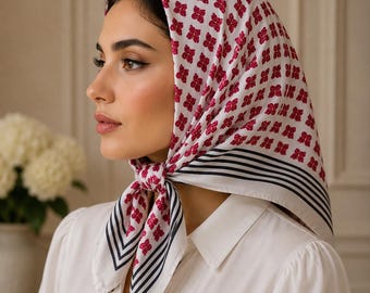 May include: A square headscarf featuring a white base with a repeating pattern of small magenta butterfly motifs. The edges of the scarf are decorated with a series of thin, parallel black stripes that frame the design, tied securely under the chin.