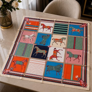 May include: A square silk scarf featuring a grid pattern of twelve panels. Each panel displays illustrations of horses in various colors, including orange, blue, pink, and green, alongside geometric stripes, plaid motifs, and small crown icons.